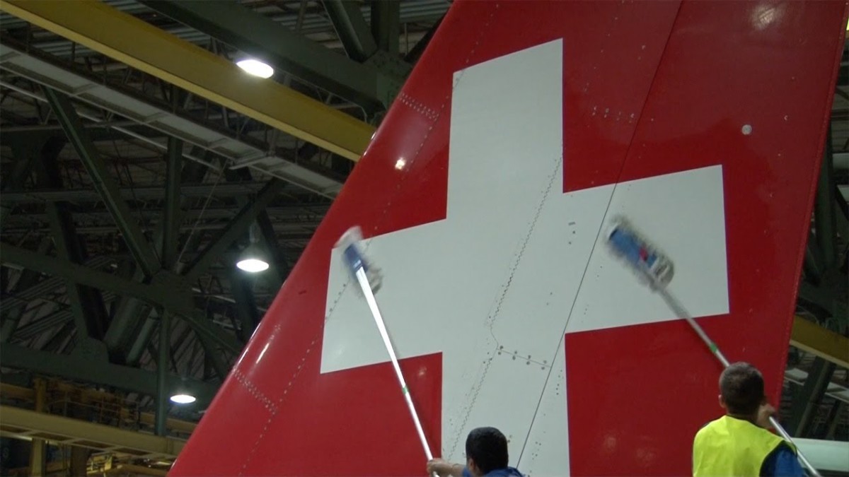 solventi non abrasivi, spugne, bastoni a lunghezza variabile e olio di gomito: si lava il timone di coda di un Swiss International Air Lines Airbus A320